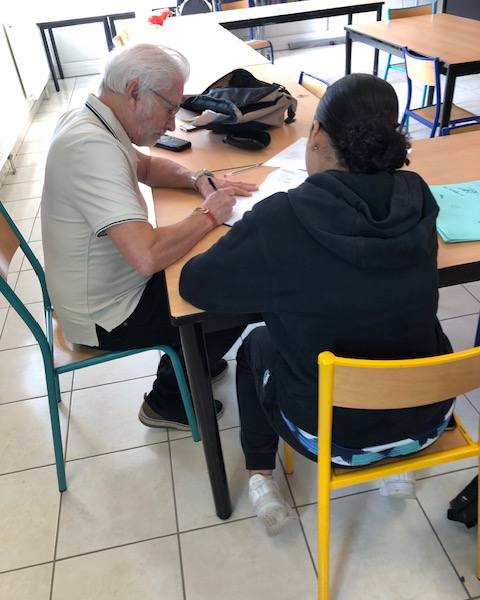 Un bénévole accompagne une élève pendant l’aide aux devoirs